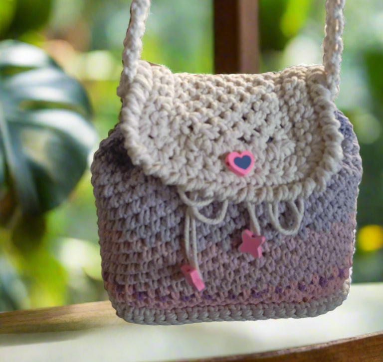 Sac en crochet avec une fermeture à rabat, décoré d'un cœur et de petites étoiles.