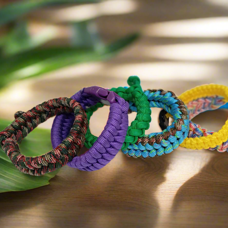 Bracelets colorés en macramé, disposés sur une surface en bois, avec lumière naturelle.