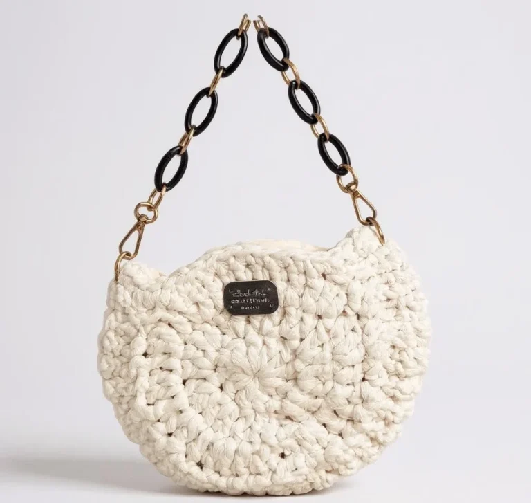 Sac à main en crochet beige avec chaîne en relief noire.