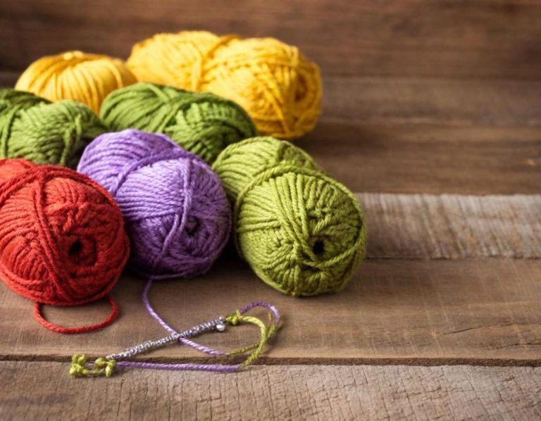 Bonnets de laine colorés sur une surface en bois.